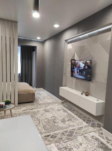 a bedroom with a television on a wall at Апартаменты ЖК Lotus Terrace in Almaty