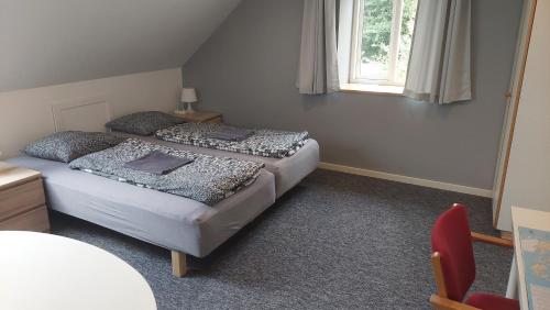 1 dormitorio con 2 camas y ventana en Ringslund B&B, en Galten