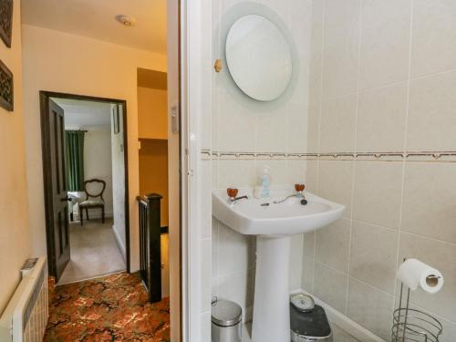 a bathroom with a sink and a mirror on the wall at 2 Gateside Cottages in Coniston