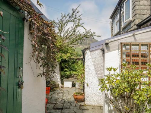 a garden entrance to a house with a green door at 2 Gateside Cottages in Coniston
