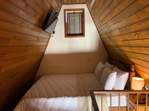 een kleine kamer met een bed op zolder bij Pousada Chalés Olaria - Exclusiva para Casais in Tiradentes