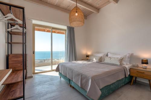 a bedroom with a bed and a view of the ocean at Alma Natura Villas Falasarna- Aphroditi Villa in Falasarna