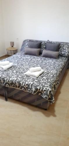 a large bed with black and white sheets and pillows at Family house Utjeha in Bar