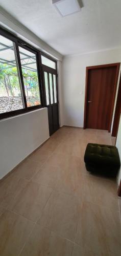 a empty room with a green ottoman in a room with windows at Family house Utjeha in Bar