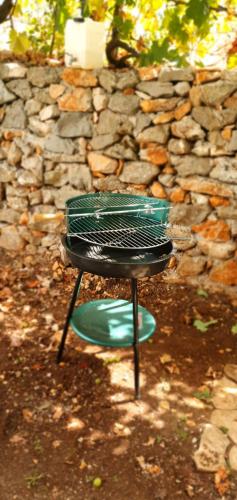 a black grill sitting in front of a stone wall at Family house Utjeha in Bar