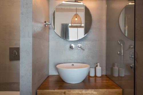 La salle de bains est pourvue d'un lavabo blanc et d'un miroir. dans l'établissement Alma Natura Villas Falasarna- Aphroditi Villa, à Falasarna