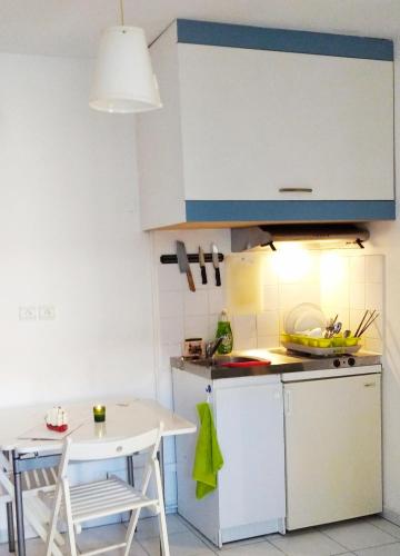 une cuisine avec une table et un réfrigérateur blanc dans l'établissement T2 Castellane 15 minute Vélodrome Vieux-Port Plage, à Marseille