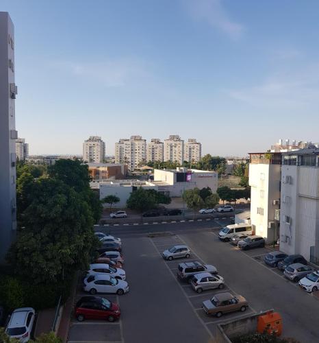 a parking lot with parked cars in a city at Cozy Flat with Parking well-placed near TLV Airport in Lod