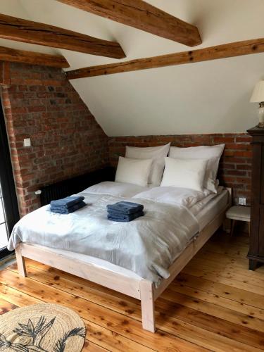 a large bed in a room with a brick wall at Dolina Zdrowia u Skrzypków in Wleń