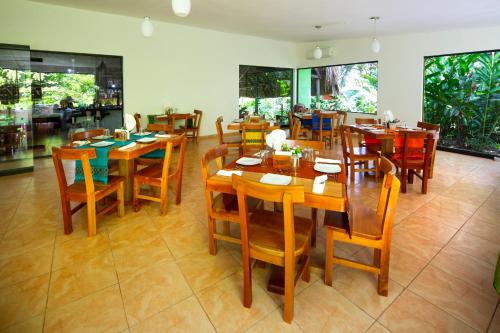 ein Esszimmer mit Holztischen und -stühlen in der Unterkunft Hotel La Aldea del Halach Huinic in Palenque