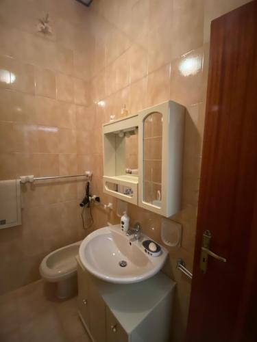 bagno con lavandino, servizi igienici e specchio di Casa Fontanelle a Burgio