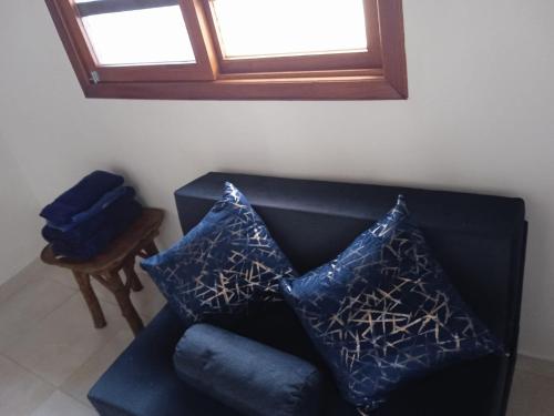 a black couch with two blue pillows on it at Hotel SoleMare in Montañita