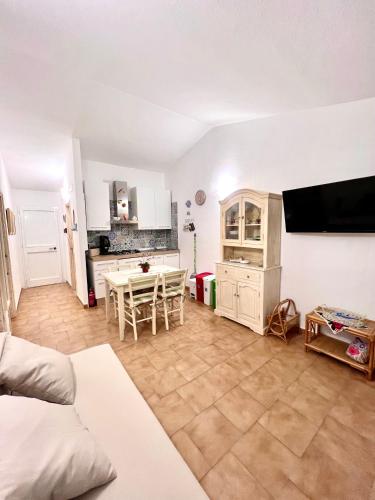 a living room with a table and a kitchen at DOMUS HENRICUS -THREEROOM APARTMENT IN PORTO POLLO 400 Meters from the sea in Porto Pollo