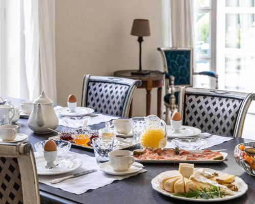 una mesa de comedor con comida y huevos. en La Castagnère de Bergory en Wervicq-Sud