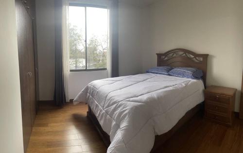Un dormitorio con una cama grande y una ventana en Lujoso depto. en ”Torre Nur” en Cochabamba