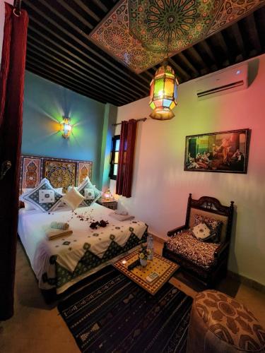 a bedroom with a bed and a chair in it at Riad Dar Kassim in Fès