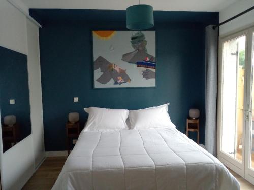 een slaapkamer met een groot bed met een blauwe muur bij Le gîte de la salicorne in Marck