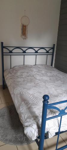 een bed met een zwart frame en een wit dekbed bij Maison des Flandres in Oxelaere