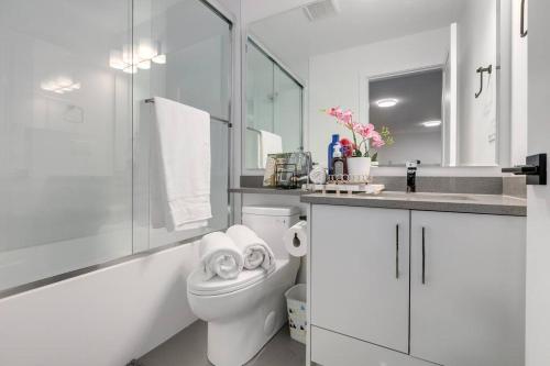 a white bathroom with a toilet and a sink at Guest suite in South Surrey in Surrey