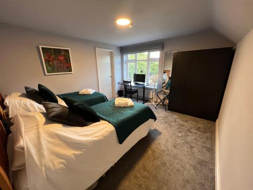 1 dormitorio con 2 camas, mesa y ventana en The Six Bells en Newbury