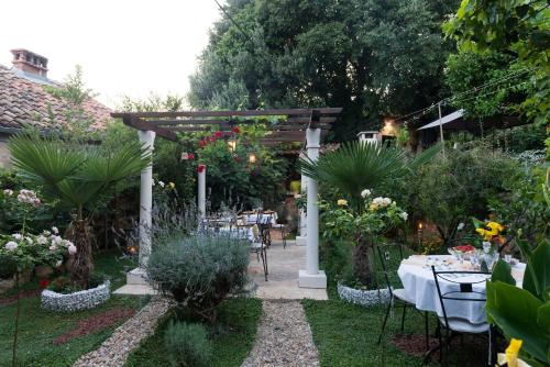 a garden with a table and a wooden pergola at B&B Villa Dubrovnik Garden in Dubrovnik