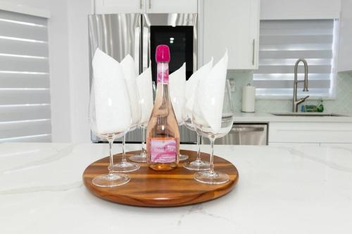 uma garrafa de vinho numa tábua de corte com dois copos de vinho em LOVING DREAM VACATION HOME em Miami