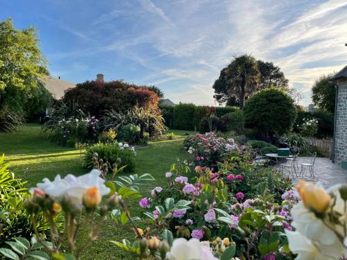 a garden with lots of flowers in a yard at Fleur & Mer in Montfarville