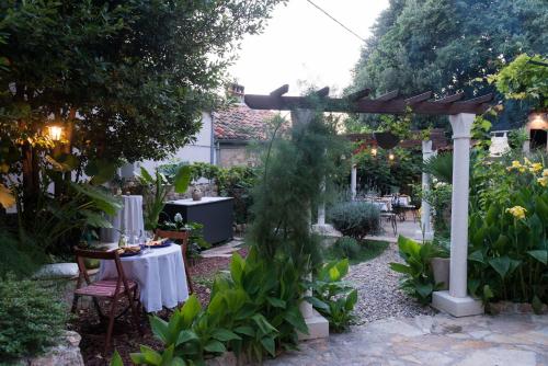 a garden with a table and a pergola at B&B Villa Dubrovnik Garden in Dubrovnik