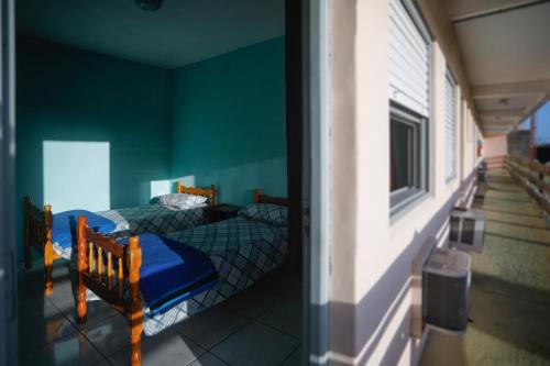 duas camas num quarto com paredes verdes em Pousada Guarida em Rio Grande