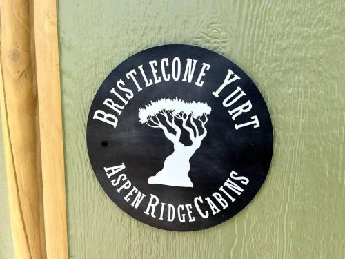 a sign on a wall with a tree on it at Bristlecone Yurt at Aspen Ridge Cabins in South Fork