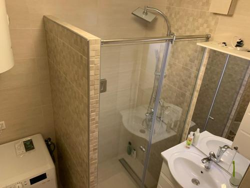 uma casa de banho com um chuveiro, um lavatório e um WC. em Apartman Nova Varos em Banja Luka