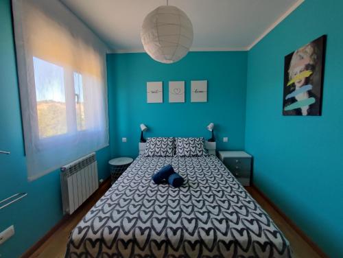 a bedroom with a bed with a blue wall at El Mirador de Murillo in Murillo de Río Leza