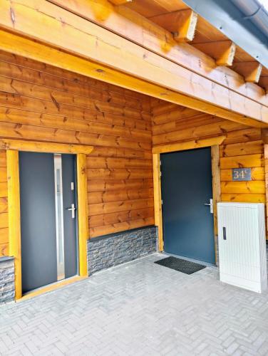 two doors on a house with wooden walls at Chalet Momage dichtbij Skiliften, Skiverhuur en Bikepark! in Winterberg