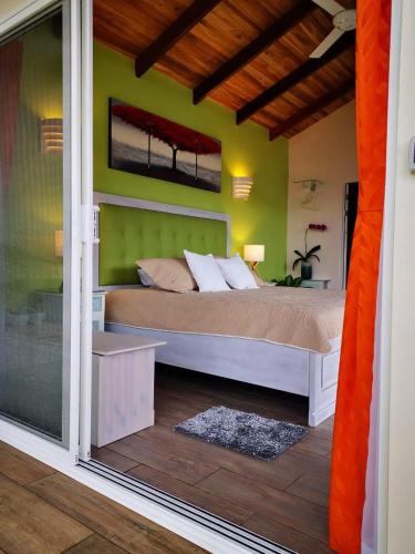 a bedroom with a large bed with green walls at Bungalows Sanlaz in Barrio Jesús