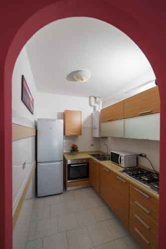 a kitchen with a white refrigerator and wooden cabinets at Casa Aidee in Varenna