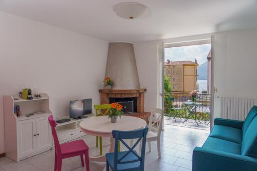 a living room with a table and chairs and a fireplace at Casa Aidee in Varenna