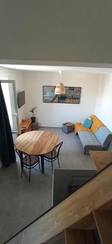 un salon avec une table et un canapé dans l'établissement Maison 1862 - Hébergements d'hôte, à Orsan