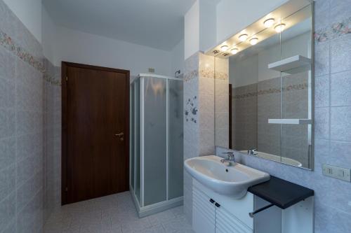 a bathroom with a sink and a shower and a mirror at Casa Aidee in Varenna