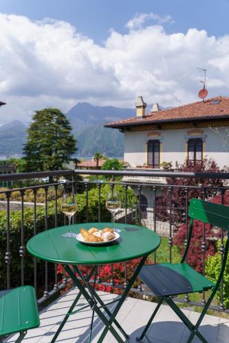 a table with a plate of food and wine glasses on a balcony at Casa Aidee in Varenna