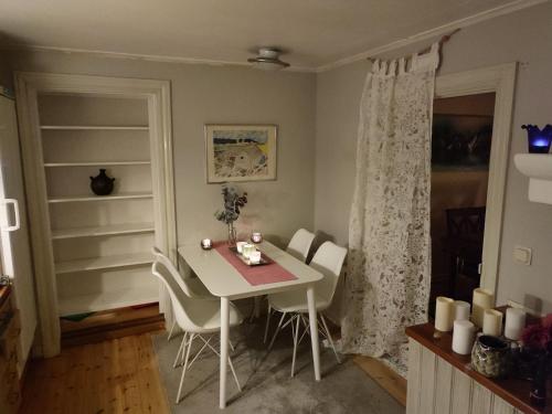 諾爾泰利耶的住宿－Den Unika Sekelskiftsvåningen.，一间配备有白色桌椅的用餐室