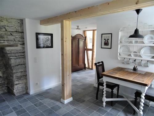 a dining room with a table and a stone wall at Stachelburg in Monschau