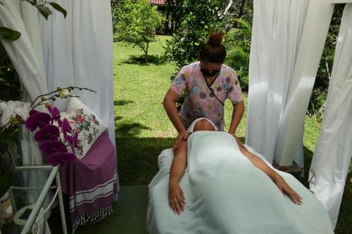 Una mujer está haciendo una mujer acostada en una cama en Bungalows Sanlaz en Barrio Jesús