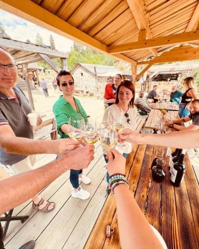 a group of people sitting around a table drinking wine at Heshkili huts and cabins Svaneti in Keshkili