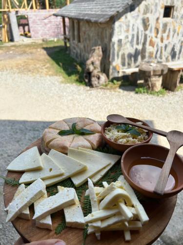 a plate of food with cheese and dip on a table at Heshkili huts and cabins Svaneti in Keshkili