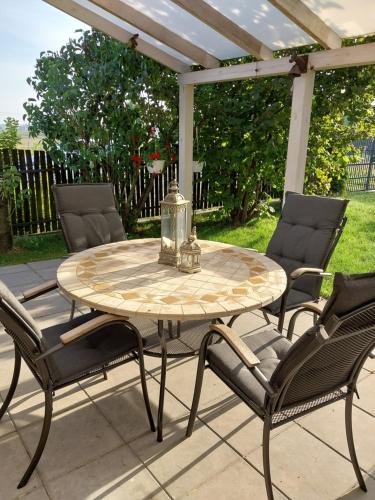 a table and four chairs on a patio at Domek przy winnicy in Kolonia Depułtycze Królewskie