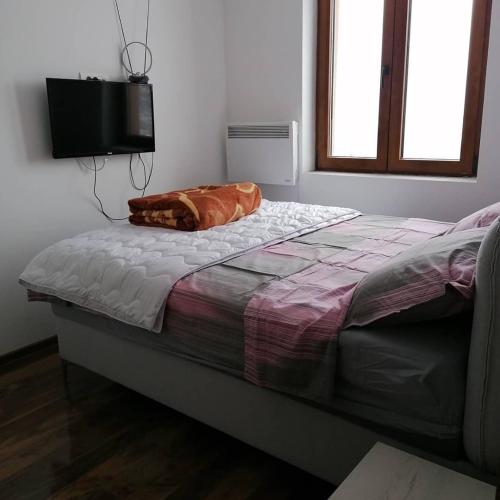 ein Bett mit einem Kissen darauf in einem Schlafzimmer in der Unterkunft Apartman Petar in Nova Varoš