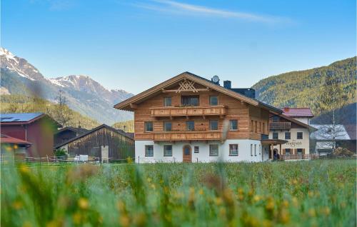 a large wooden house with mountains in the background at Sehr Schoene Ferienwohnung in Längenfeld