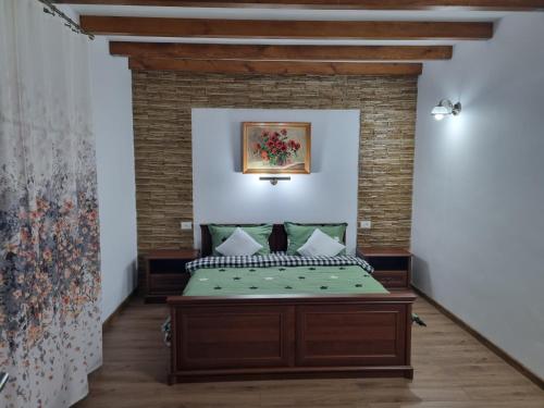 een bed in een kamer met een bakstenen muur bij Casa Lucia in Anina