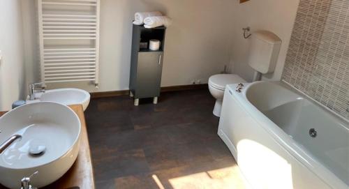 a bathroom with two sinks and a tub and a toilet at Ex Villa Gastaldi in Asti