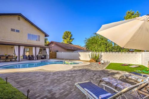a patio with an umbrella and chairs and a pool at Hidden Gem in the Desert -Gym/Pool/Spa/Games-4BR in Spring Valley